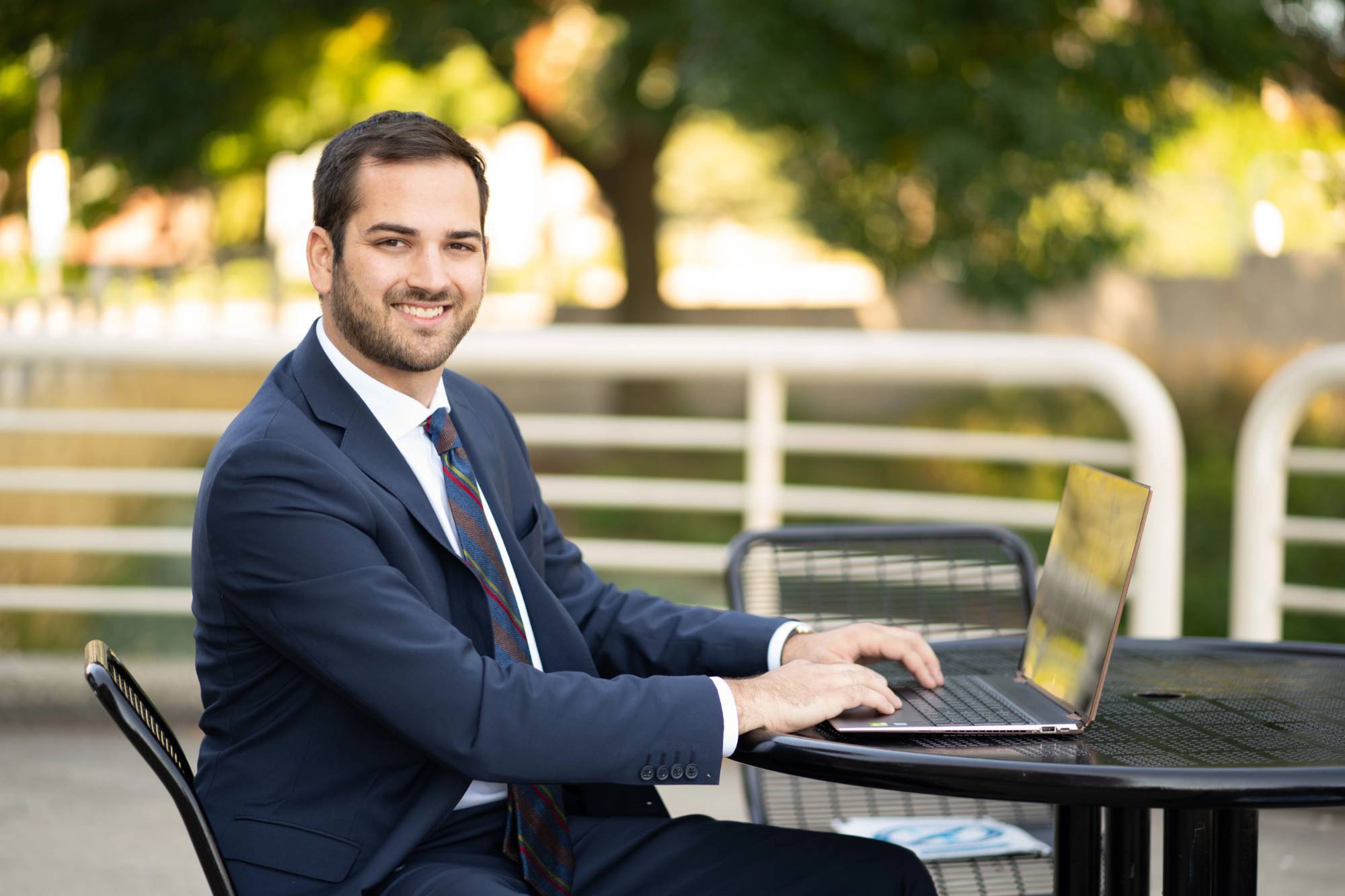 a GVSU adult student alum working on his computer outside